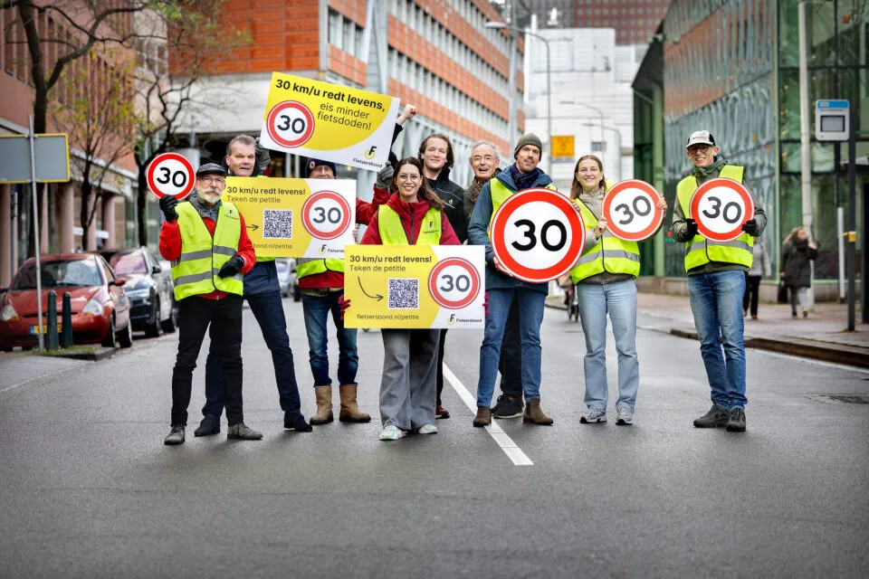 Actievoerders in Breda met 30 km borden pleiten voor verlaging maximumsnelheid in bebouwde kom voor meer verkeersveiligheid
